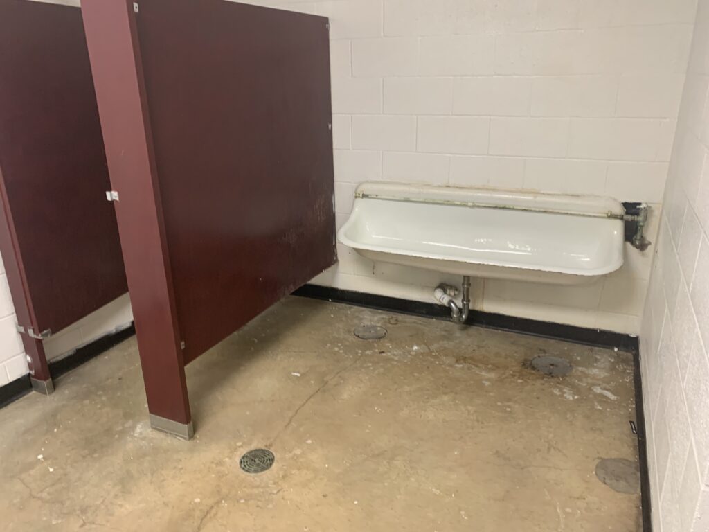 Boy's locker room under basketball stands (urinals)